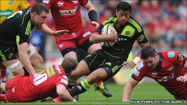 Munster's Lifemi Mafi is tackled by Scarlets fly-half Rhys Priestland