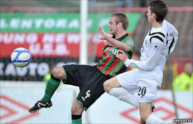 Glentoran's Richard Clarke in action against Jordan Forsythe of Lisburn Distillery