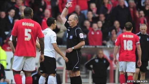 Referee Mike Dean sends off Swansea defender Neil Taylor at Nottingham Forest