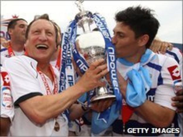 QPR boss Neil Warnock holds the Championship trophy with Alejandro Faurlin, the midfielder whose transfer to the club had been at the centre of the FA hearing