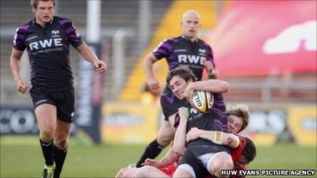 Ospreys centre Andrew Bishop is pulled down by the Munster defence as Dan Biggar (left) and Richard Fussell look on