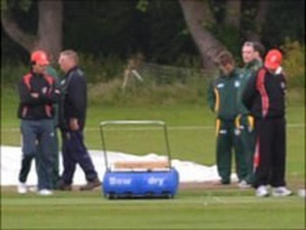 Guernsey cricket players and umpires inspecting KGV under rainy conditions