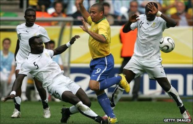 Brazil's Ronaldo (in yellow) is tackled by Ghana's John Mensah (number 5) as Sulley Muntari (number 11) takes evasive action