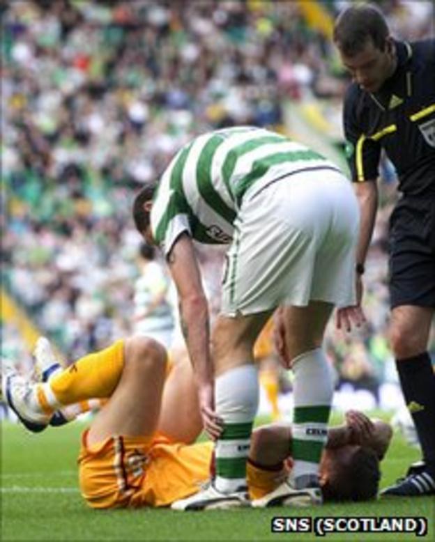 Celtic striker Anthony Stokes checks on Shaun Hutchinson who is grounded