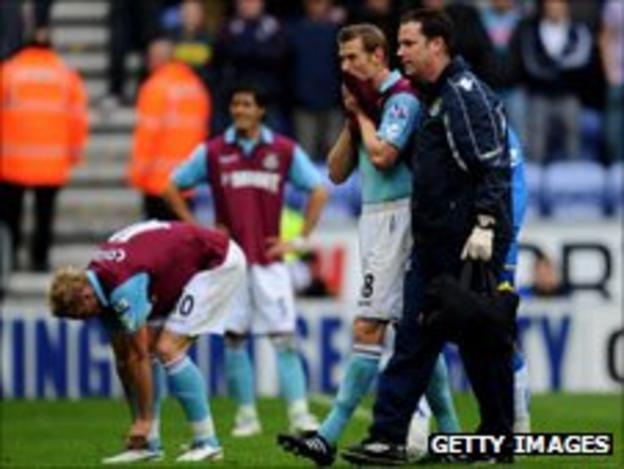 West Ham's Jonathan Spector (right) is consoled after the club's relegation from the Premier League