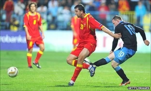 Wayne Rooney of England kicks Miodrag Dzudovic of Montenegro