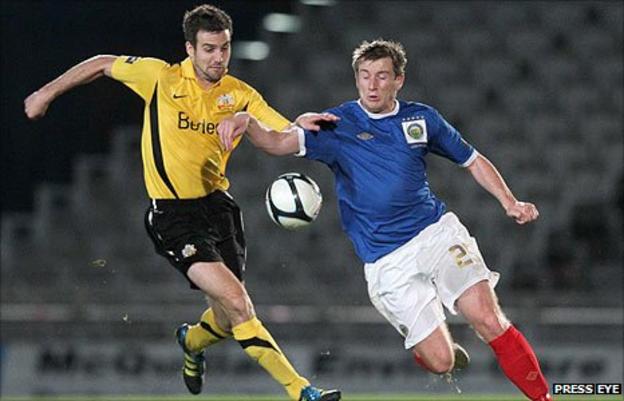 Glenavon defender Mark Turkington challenges Linfield forward Mark McAllister at Windsor Park