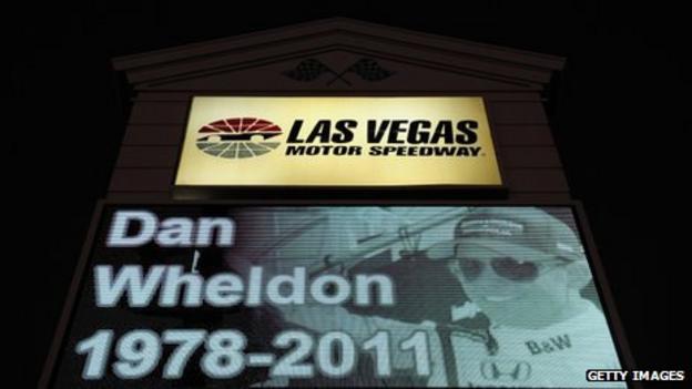 A memorial to Dan Wheldon is displayed on a Las Vegas Motor Speedway sign