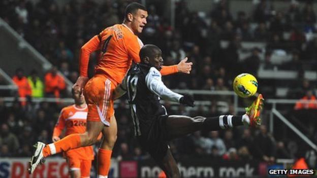 Swansea defender Steven Caulker challenges Newcastle striker Demba Ba