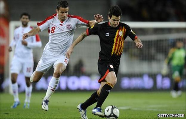 Cesc Fabregas of Catalonia (R) and Khaleo Korbi of Tunisia fight for the ball during the friendly between Catalonia and Tunisia