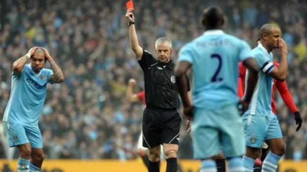Chris Foy shows Vincent Kompany a red card