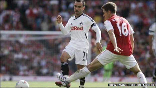 Leon Britton is challenged by Aaron Ramsey