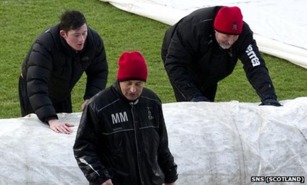 Inverness manager Terry Butcher helps get the pitch ready for his side's match agaisnt Hearts