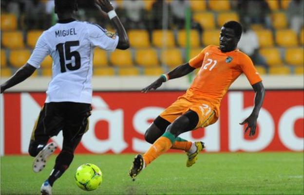 Angola's (in white) and Emmanuel Eboue of Ivory Coast (orange jersey)