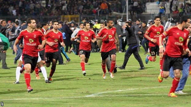 Al-Ahly players flee the pitch at the end of the game against al-Masry