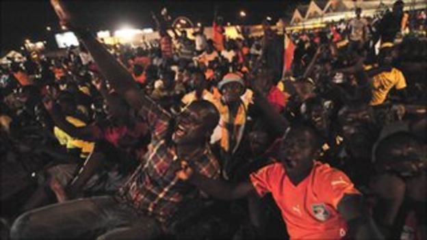 Ivorian fans celebrate an Elephants goal as they watch on a big screen in Abidjan