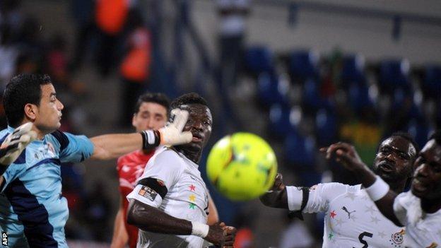Tunisia goalkeeper Aymen Mathlouthi (L) challenges for the ball with Ghana players