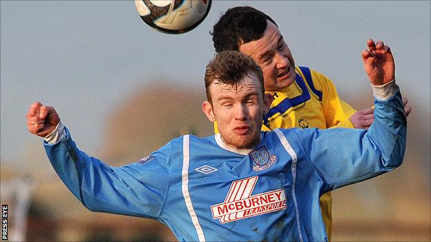 Ballymena United's Rory Carson goes up for a high ball with Conor Strong of Derriaghy