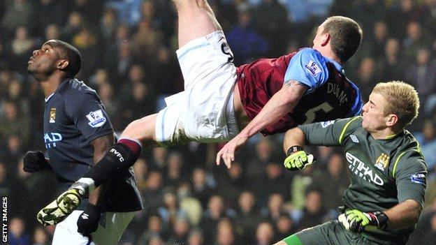 Richard Dunne goes flying after a challenge with Manchester City goalkeeper Joe Hart
