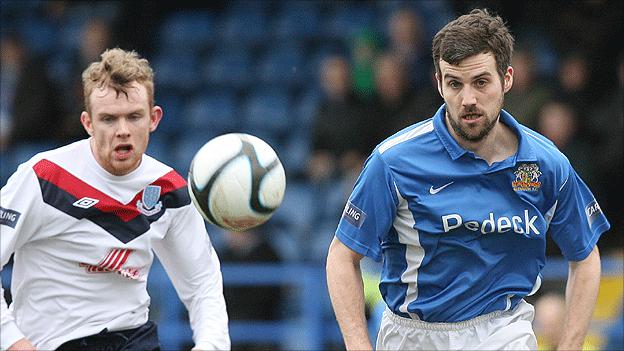 Rory Carson of Ballymena goes for the ball with Glenavon opponent Mark Turkington