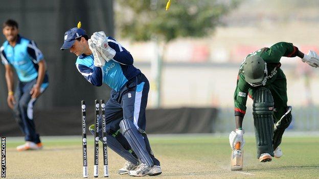 Scotland wicket keeper Craig Wallace breaks the stumps to run out Shem Ngoche