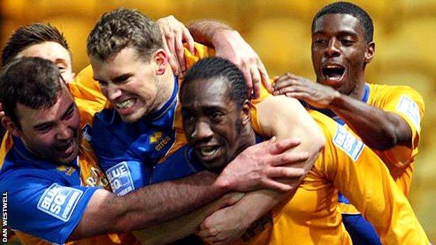 Exodus Geohaghon is mobbed by jubilant Mansfield team-mates after his equaliser against Fleetwood