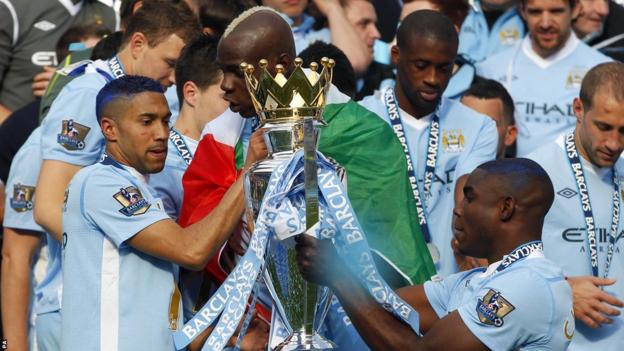 Manchester City players hold the Premier League title