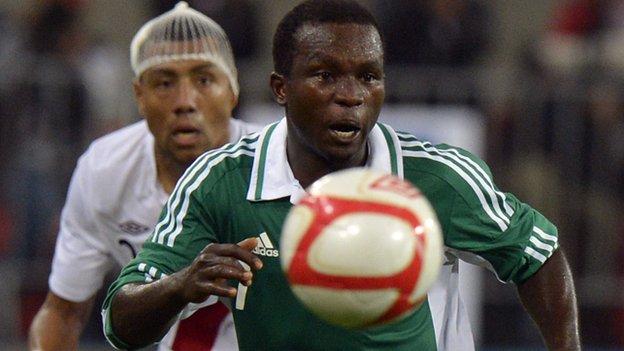Nigeria's Ejike Uzoenyi is marshalled by Peru's Luis Ramirez