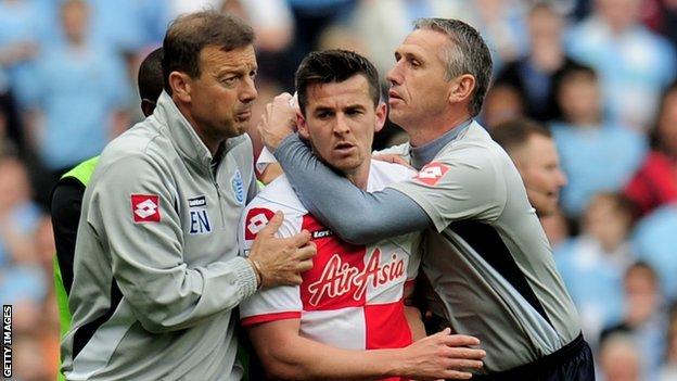QPR midfielder Joey Barton is restrained following his red card