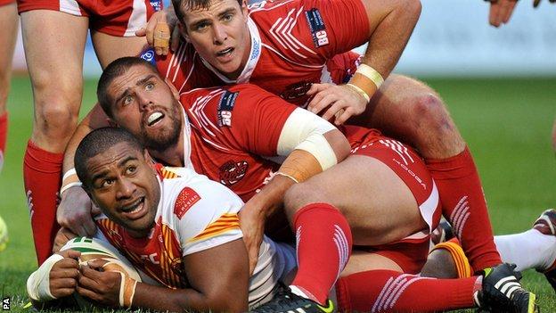 Catalans' Lopini Paea scores a try despite being held by Salford's Lee Jewitt and Matty Ashurst