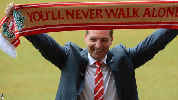 Brendan Rodgers holds a scarf aloft after being unveiled as Liverpool manager