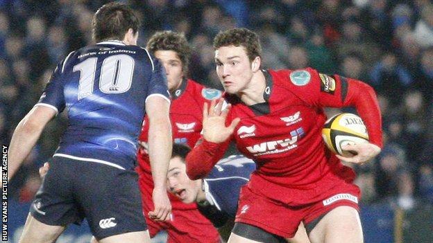 Scarlets wing George North getting ready to hand off Leinster's Jonathan Sexton