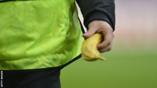 A steward holds a banana after picking it up off the pitch during the Euro 2012 football championships Group C match Italy v Croatia