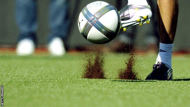 Footballer playing on an artificial pitch