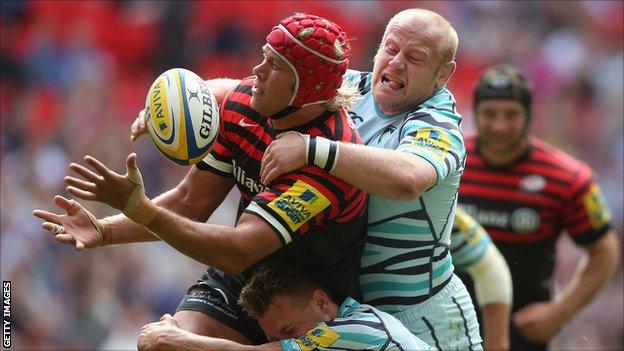 Mouritz Botha of Saracens is tackled by Leicester's Dan Cole and Sam Harrison