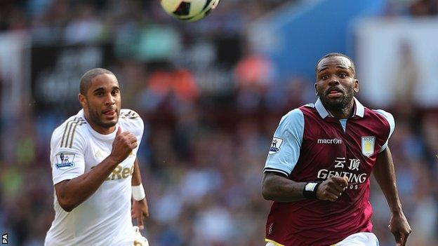 Swansea defender Ashley Williams challenges Darren Bent of Aston Villa