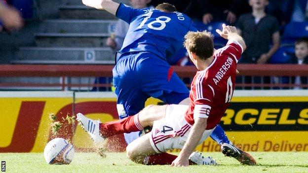 Shane Sutherland is tackled by Russell Anderson at Caledonian Stadium