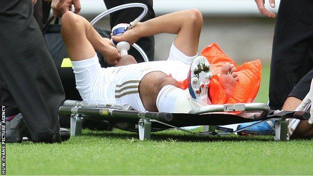 Neil Taylor lies injured on a stretcher