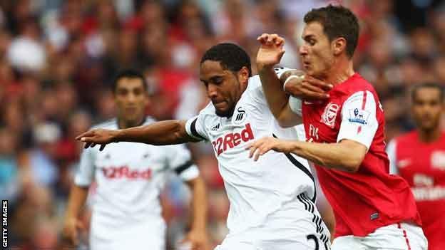 Ashley Williams and Aaron Ramsey compete for their clubs