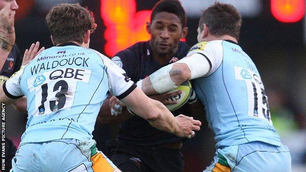 Tonderai Chavhanga is stopped by Northampton's Dominic Waldouck and Tom May