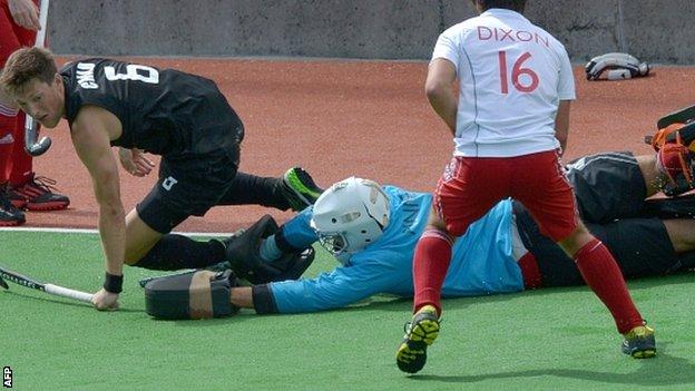 New Zealand's Simon Child tussles with England goalkeeper George Pinner