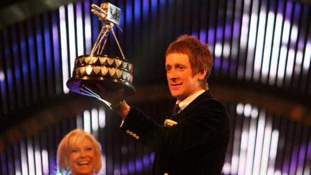 2012 Sports Personality of the Year Bradley Wiggins holds the trophy aloft after being presented it by the Duchess of Cambridge