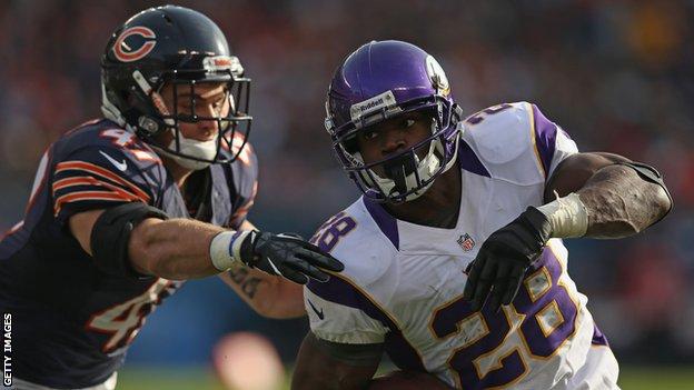 Adrian Peterson (right) powers past a member of the Chicago Bears defence