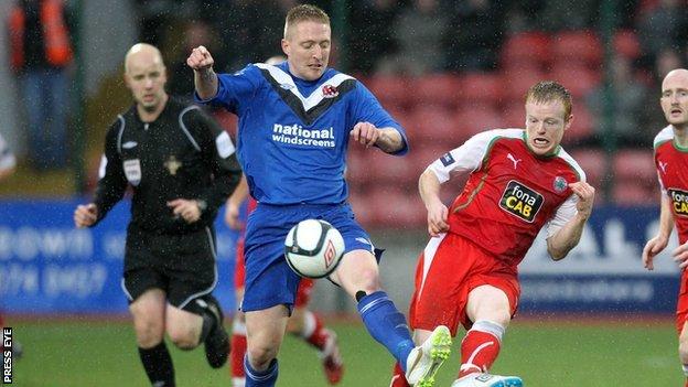 Crusaders midfielder Chris Morrow shields the ball from Cliftonville's George McMullan