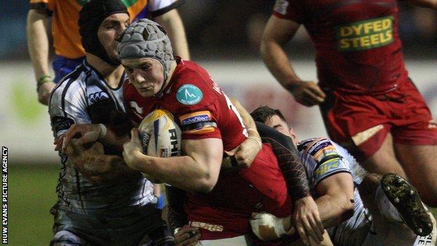 Scarlets' Jonathan Davies is brought down