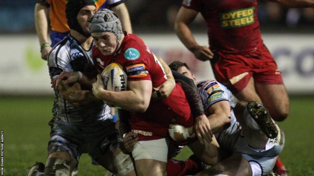 Cardiff Blues' Sam Warburton helps to bring down Scarlet Jonathan Davies in the Pro 12 at Cardiff Arms Park