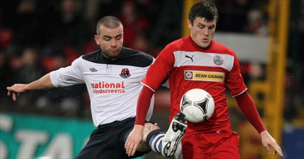 Colin Coates vies for possession with Diarmuid O'Carroll in the north Belfast derby at Solitude