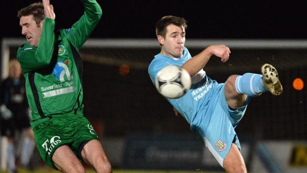 Andy Crawford of Ballinamallard United takes evasive action as Ballymena United's Ross Black clears the ball