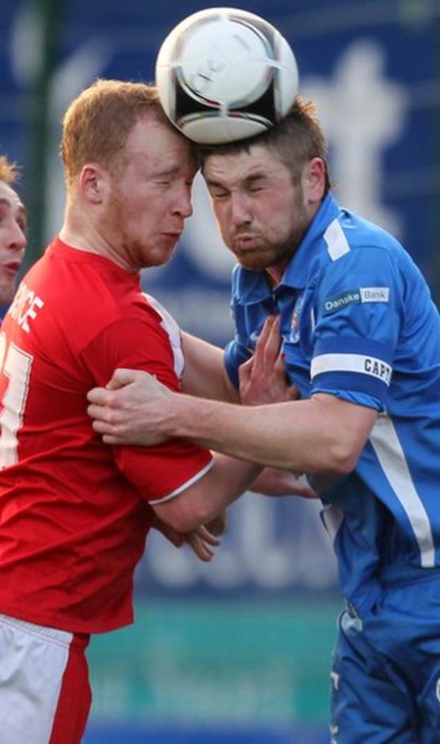Liam Boyce and Mallards defender Mark Stafford go head-to-head during Cliftonville's 4-2 victory