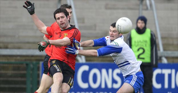 Kevin McKernan kicks the ball for Down as Owen Coyle attempts to block for Monaghan